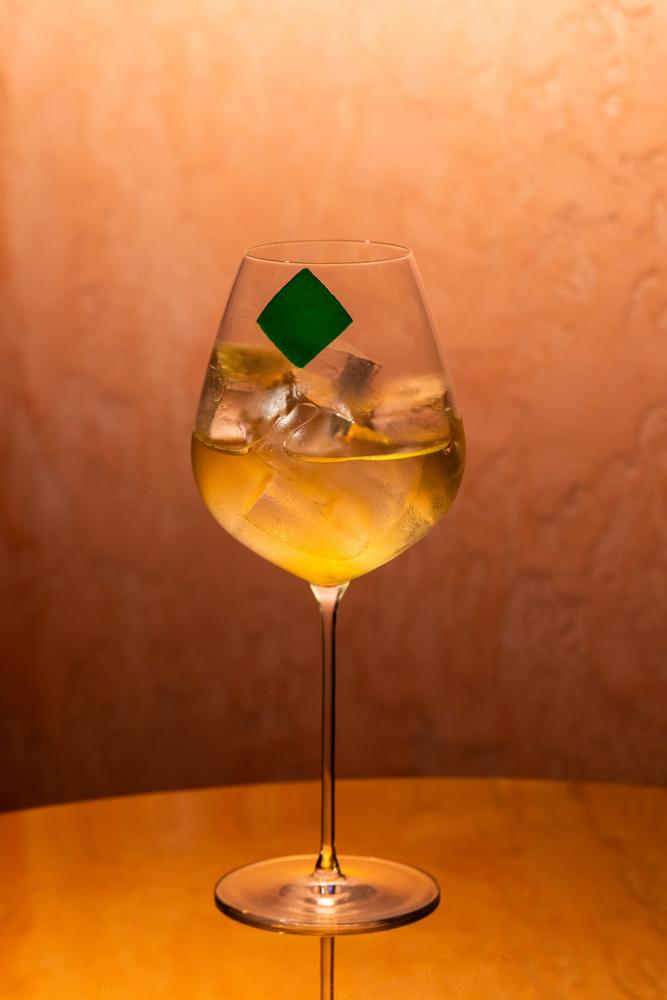 A spritz with a green garnish