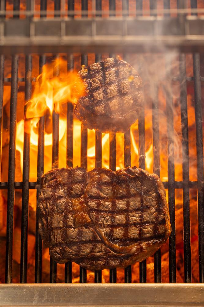 Steaks seared on the grill above the fire