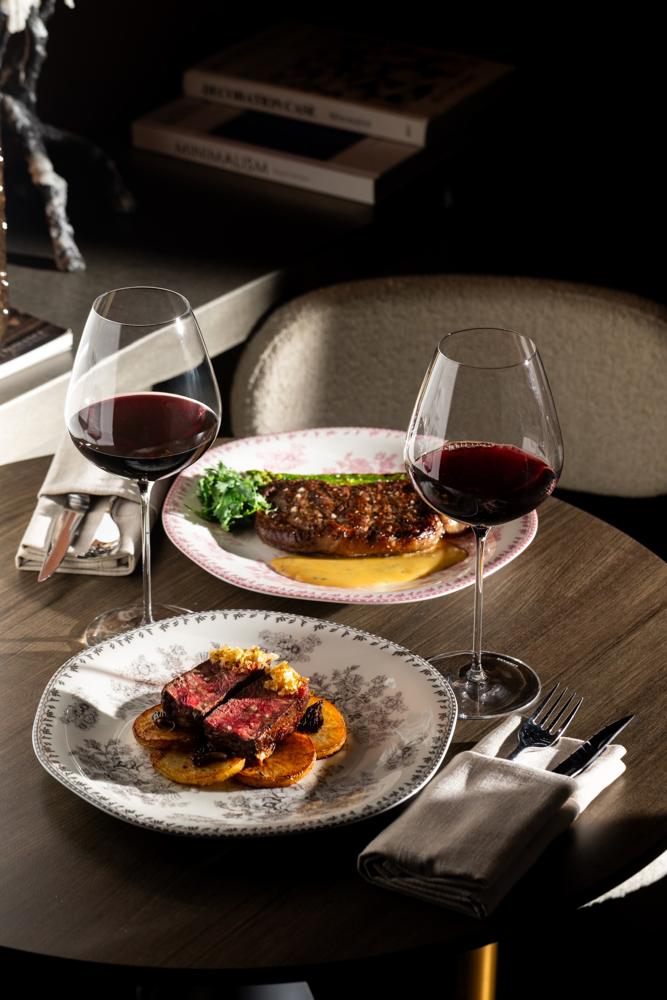 Two steaks with glasses of red wine